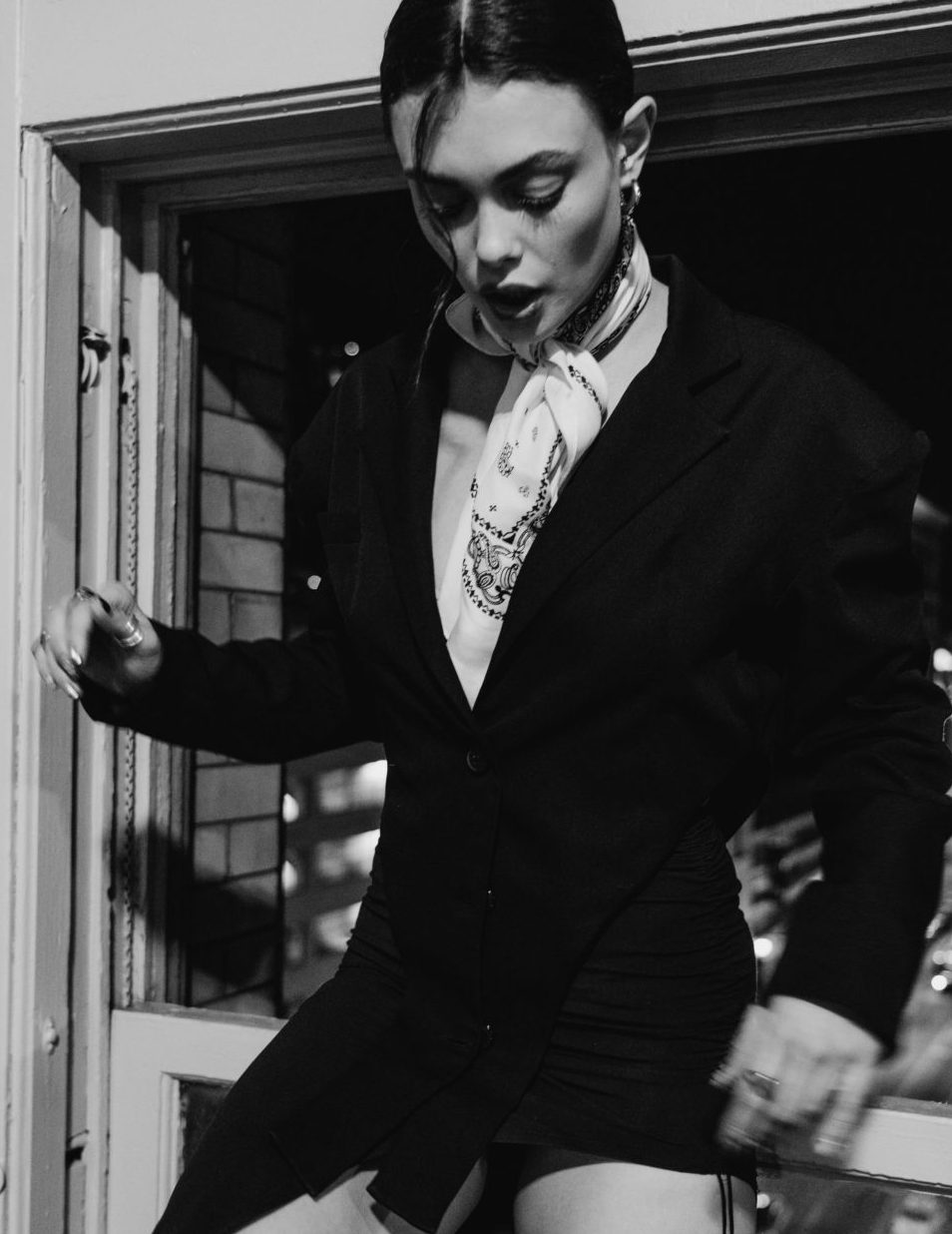 Liza in a black suit in a doorway