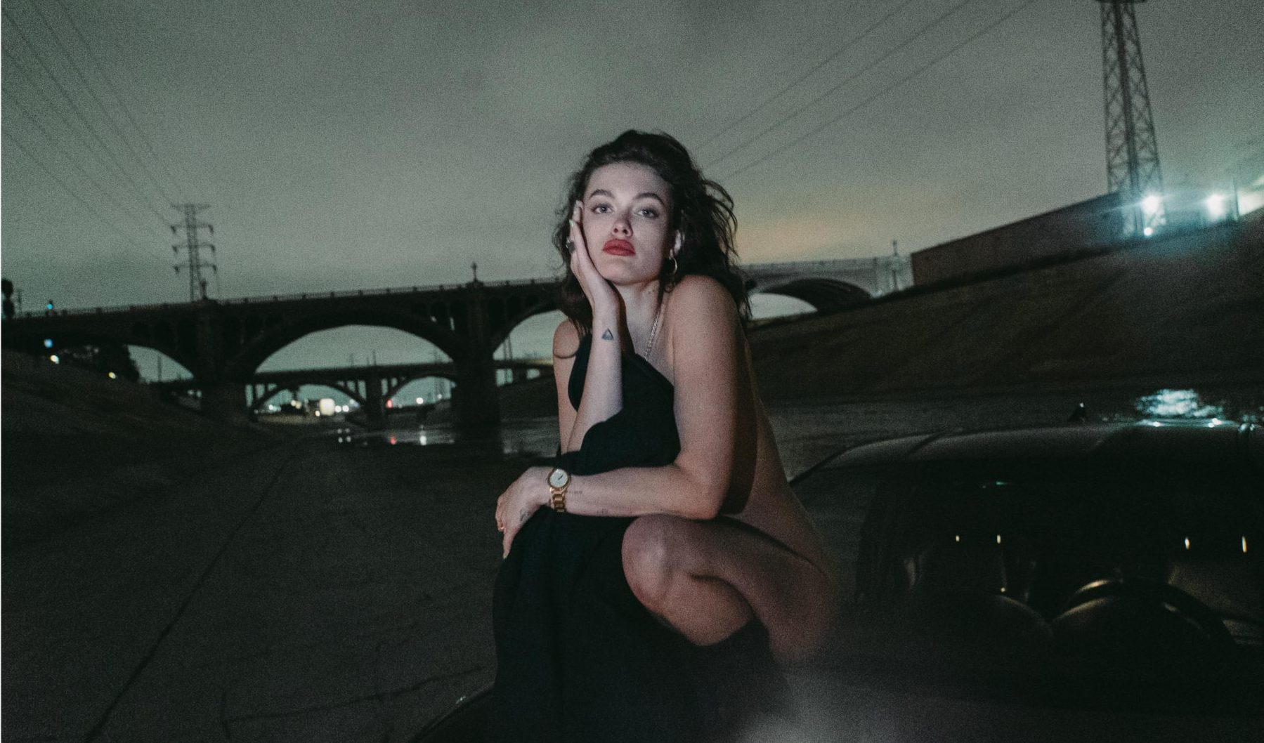 Liza Adamenko by the river under a bridge at night, Los Angeles